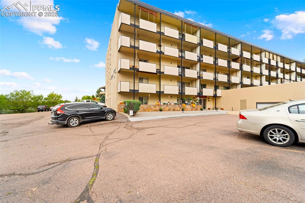 Caption: View of apartment building / complex with uncovered parking