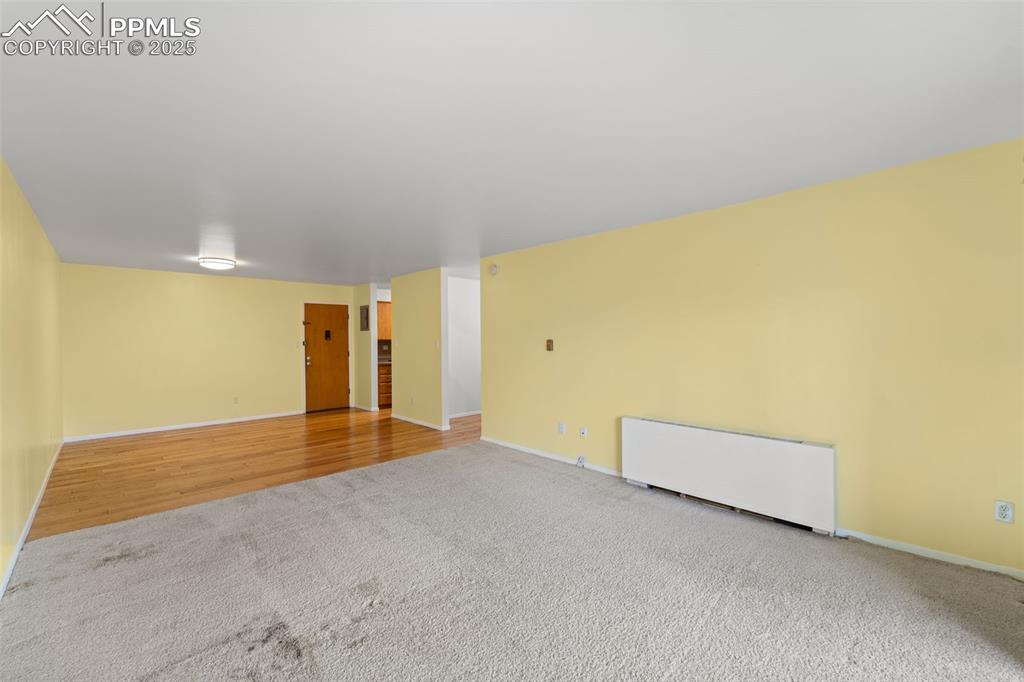 Image 14 of 23: Spare room featuring carpet floors and radiator heating unit