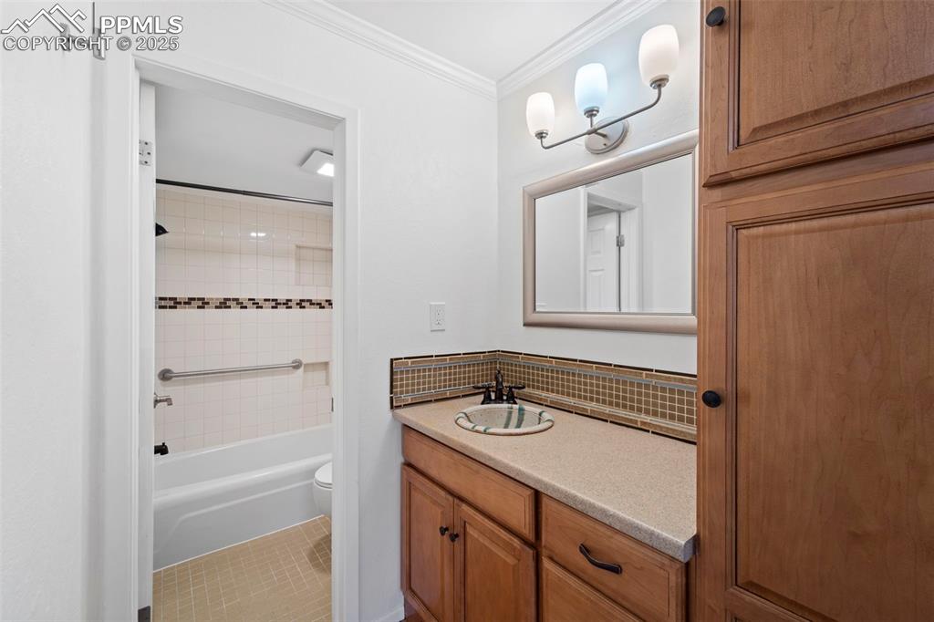Image 17 of 23: Full bath featuring vanity, ornamental molding, shower / tub combination, t