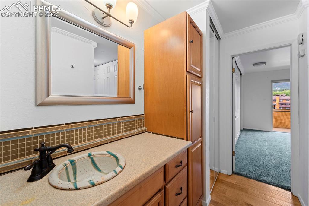 Image 22 of 23: Bathroom featuring ornamental molding, wood finished floors, vanity, and ba