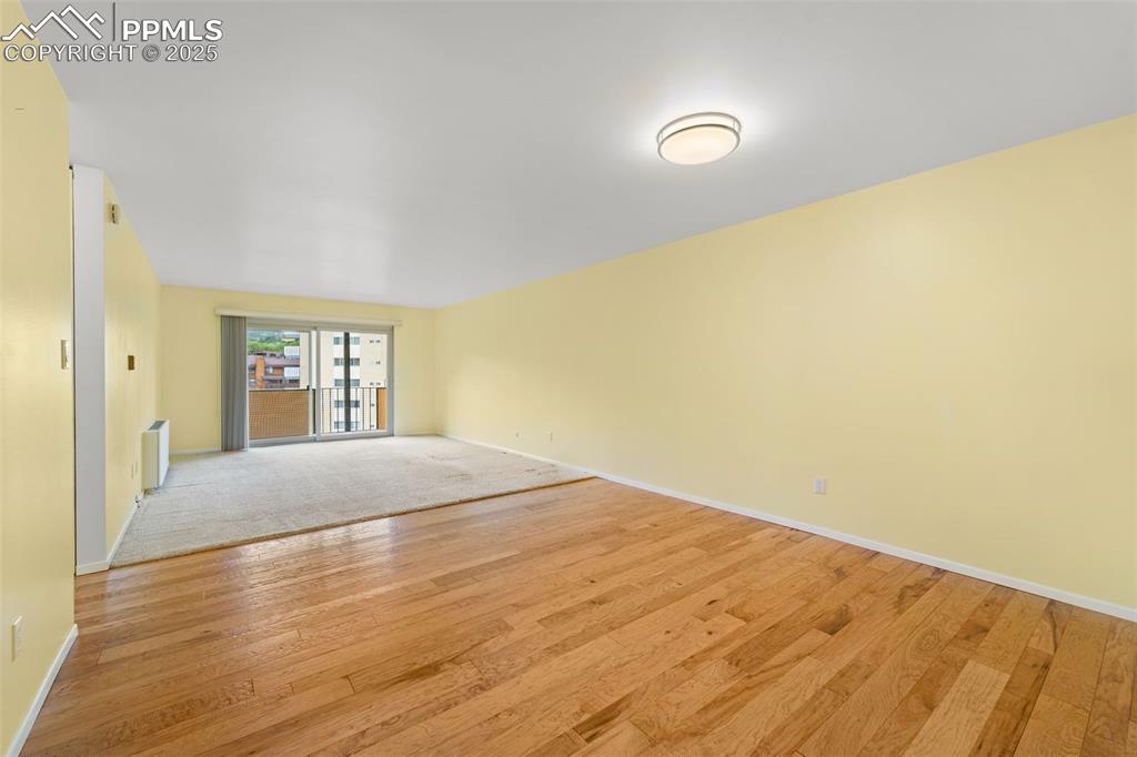 Image 6 of 23: Spare room featuring radiator heating unit and light wood-style flooring
