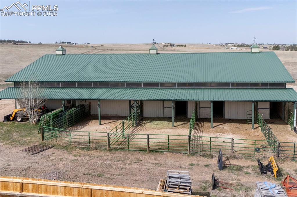 Image 38 of 50: 50x100 metal drive-through barn has a concrete floor, w/ a half bath, 4 sta