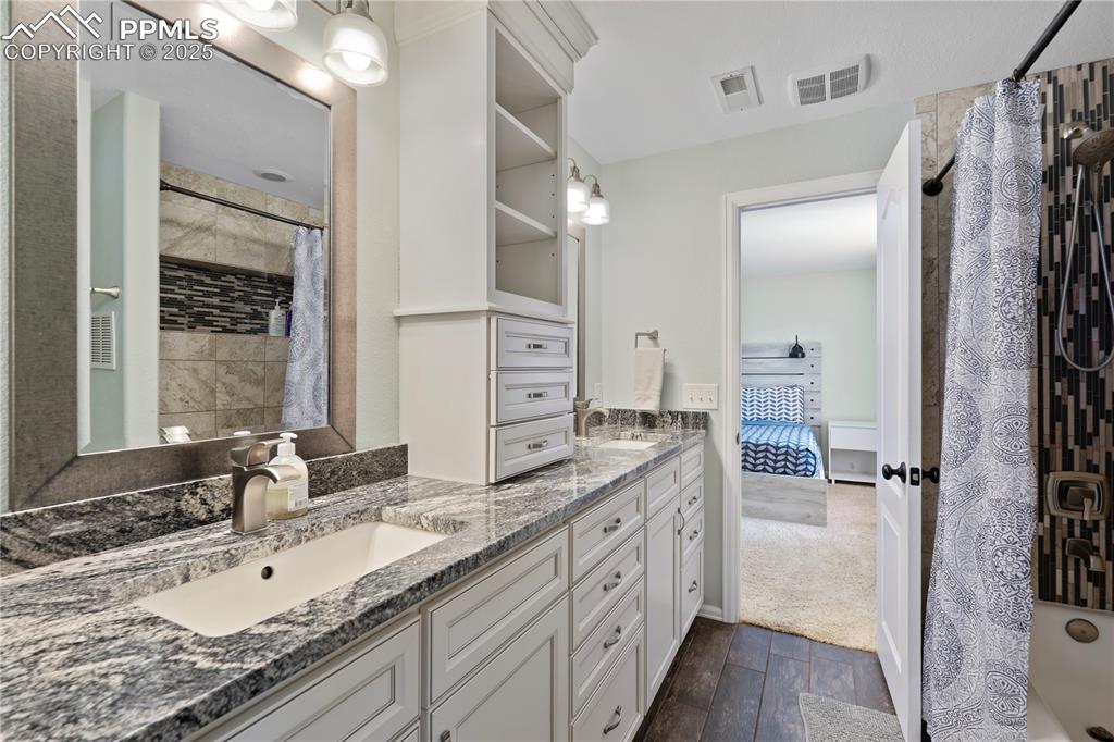 Image 22 of 37: En suite Lower Primary Bath w/granite double sinks and high-end cabinets!