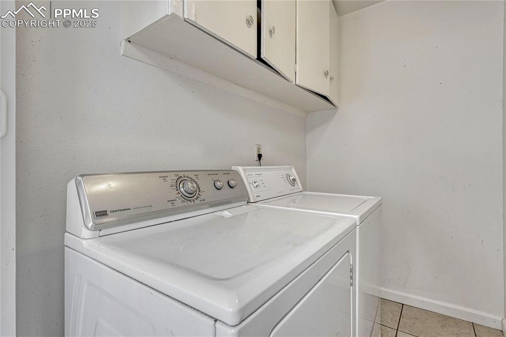 Image 25 of 43: Laundry room with cabinets.  Washer and Dryer stay!