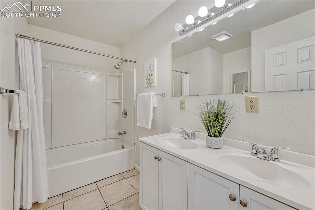 Image 7 of 43: Large Bathroom with double vanity, and tile flooring.
