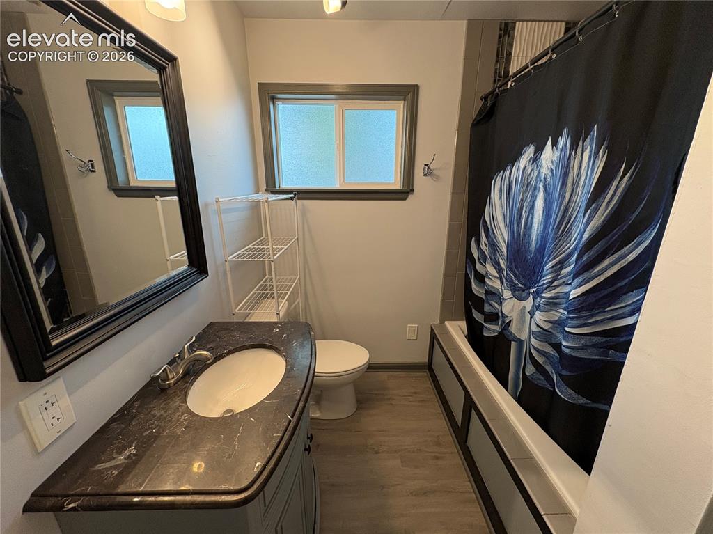 Image 7 of 12: Bathroom featuring a single vanity with a dark countertop, an oval undermou
