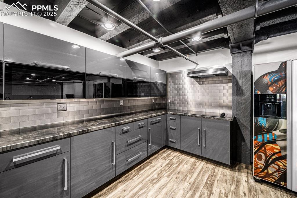 Image 15 of 32: Kitchen featuring gray cabinetry, light wood-style flooring, backsplash, da
