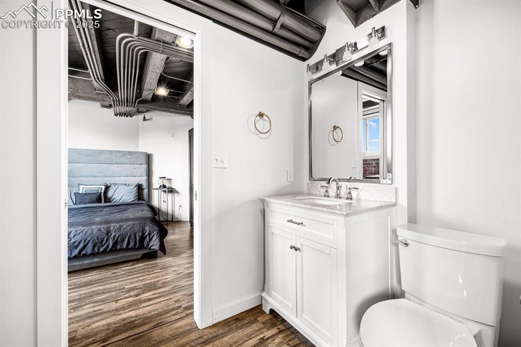 Image 19 of 32: Ensuite bathroom featuring wood finished floors and vanity
