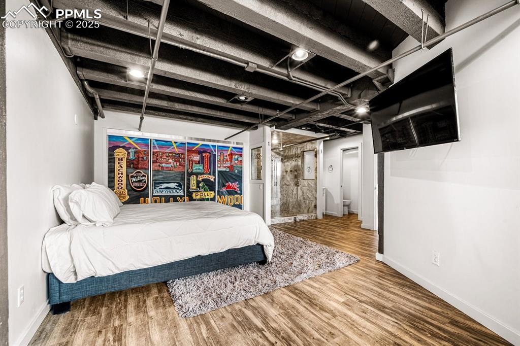Image 26 of 32: Bedroom with wood finished floors and baseboards