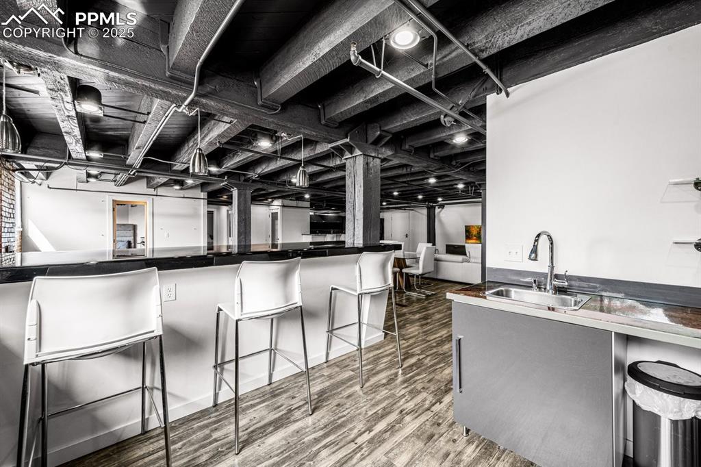 Image 5 of 32: Kitchen featuring wood finished floors, a kitchen breakfast bar, and dark c