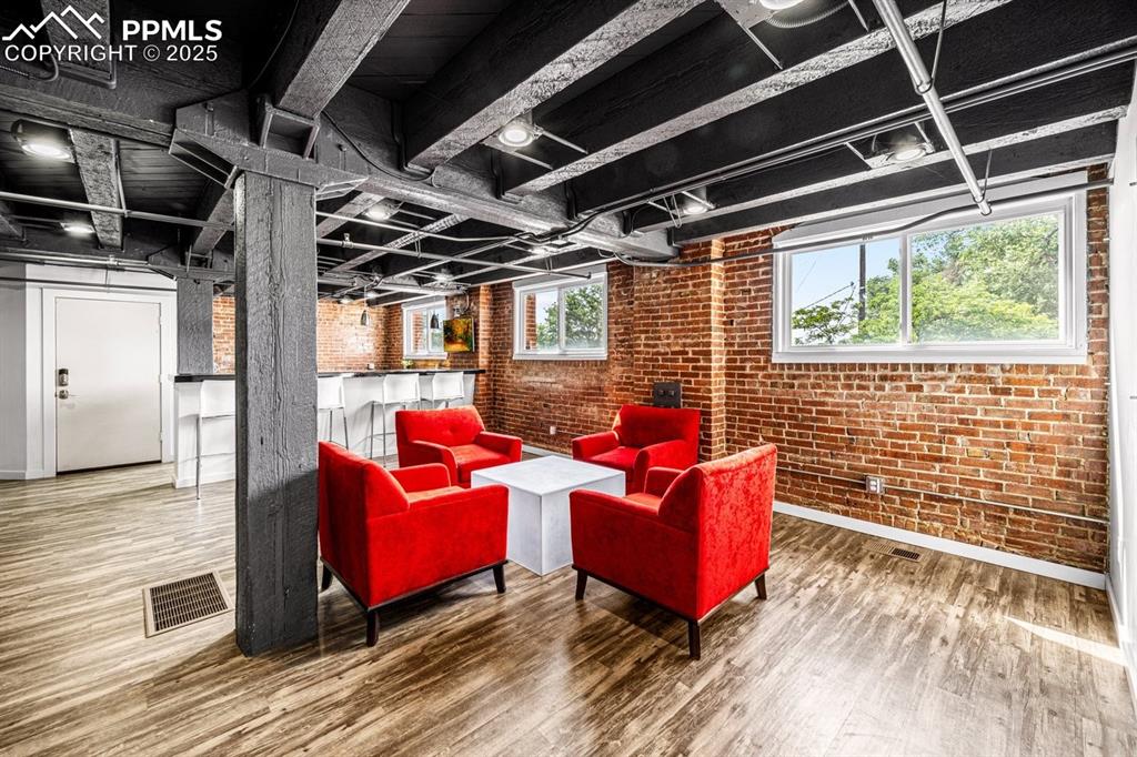 Image 9 of 32: featuring brick wall and wood finished floors