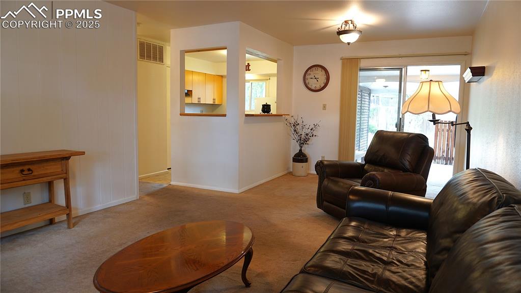 Image 4 of 23: Living and dining room with opening to kitchen and door to patio