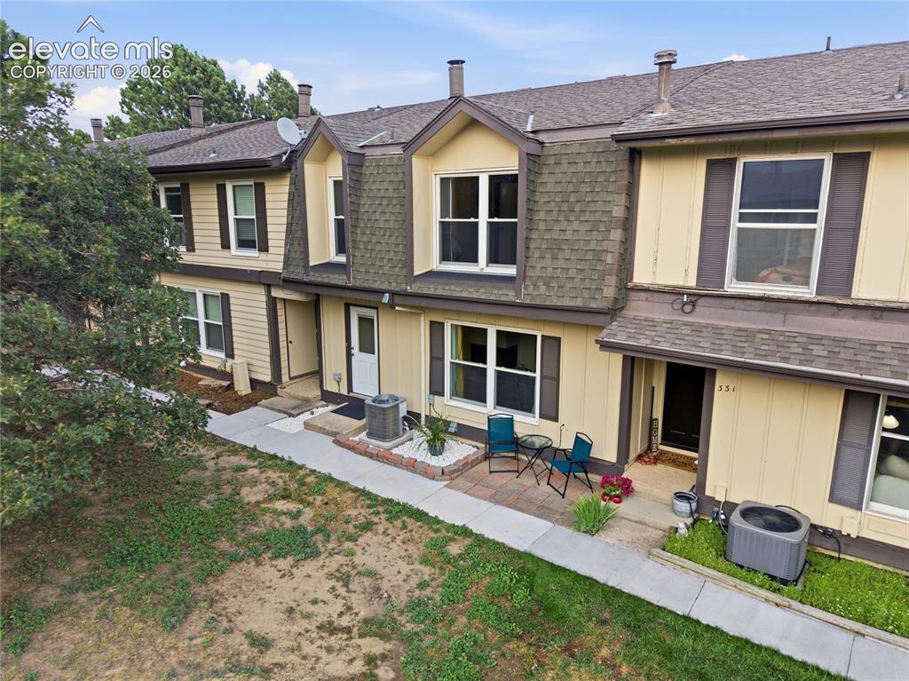 Caption: Dormer windows, dual-tone exterior siding, covered entry, and front patio with brick accents
