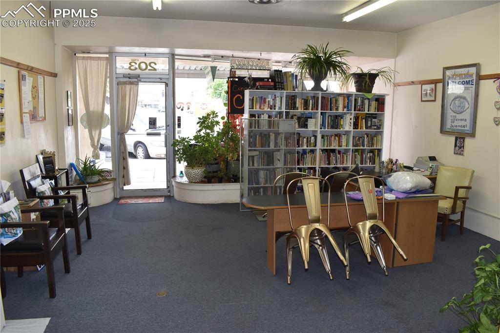 Image 10 of 37: Living area featuring dark carpet