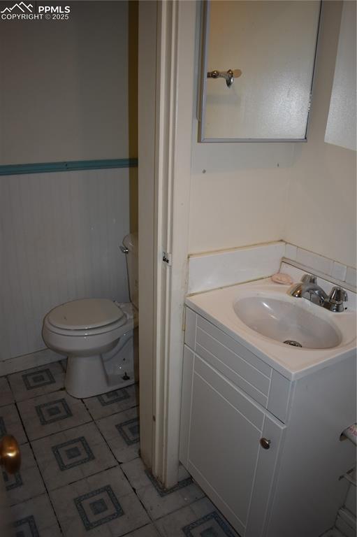 Image 19 of 37: Bathroom featuring vanity, light tile patterned floors, and wainscoting
