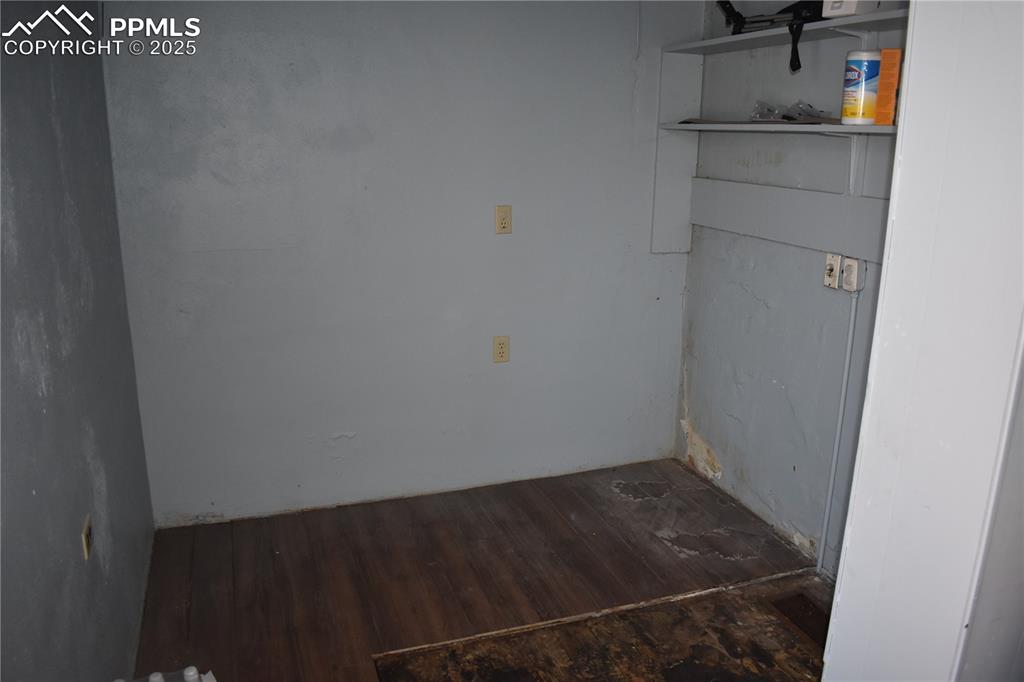 Image 32 of 37: Laundry area with dark wood finished floors