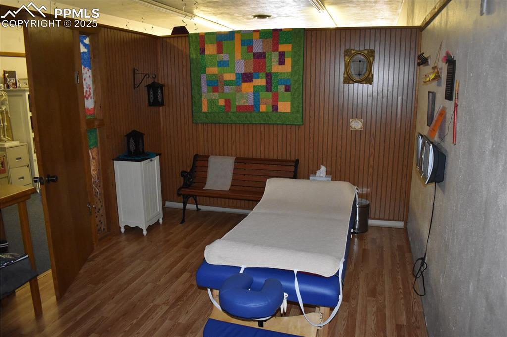 Image 5 of 37: Bedroom with wood finished floors and wooden walls
