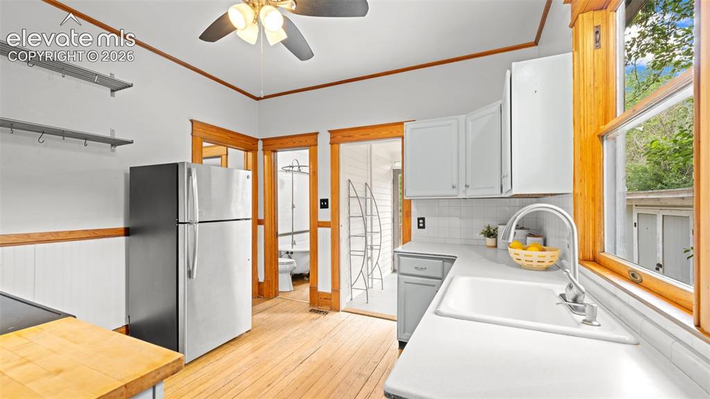 Image 14 of 38: Kitchen featuring light wood-finish flooring, white beadboard wainscoting,