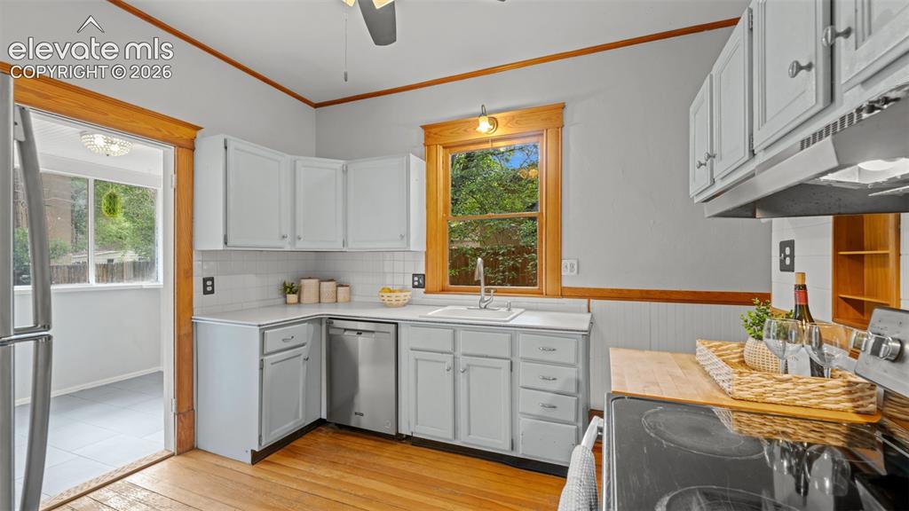 Image 15 of 38: Kitchen featuring light-painted cabinetry, stainless steel appliances, a ti