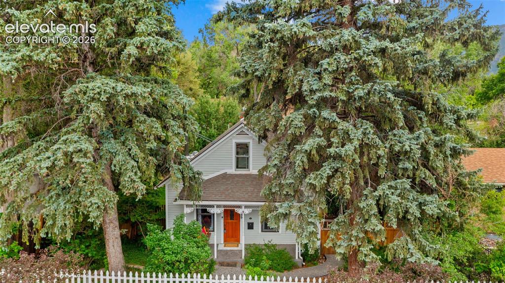 Image 27 of 38: Light gray siding exterior with a contrasting orange entry door and gable r