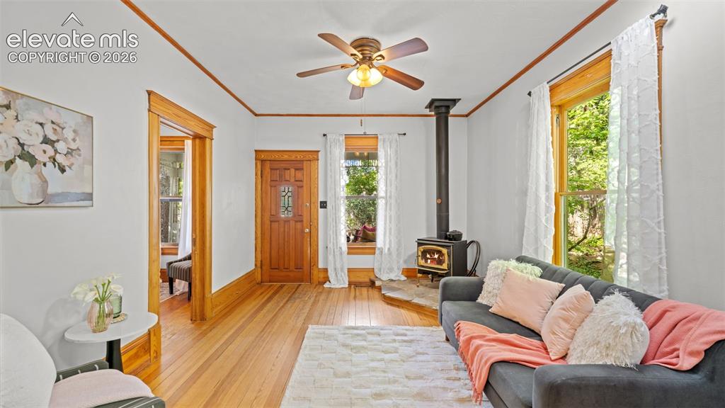 Image 7 of 38: Living area featuring wood-finish flooring, a freestanding stove with stone