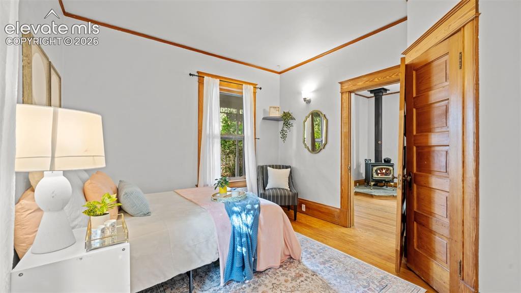 Image 9 of 38: Hardwood flooring throughout, featuring a wood-burning stove visible from t
