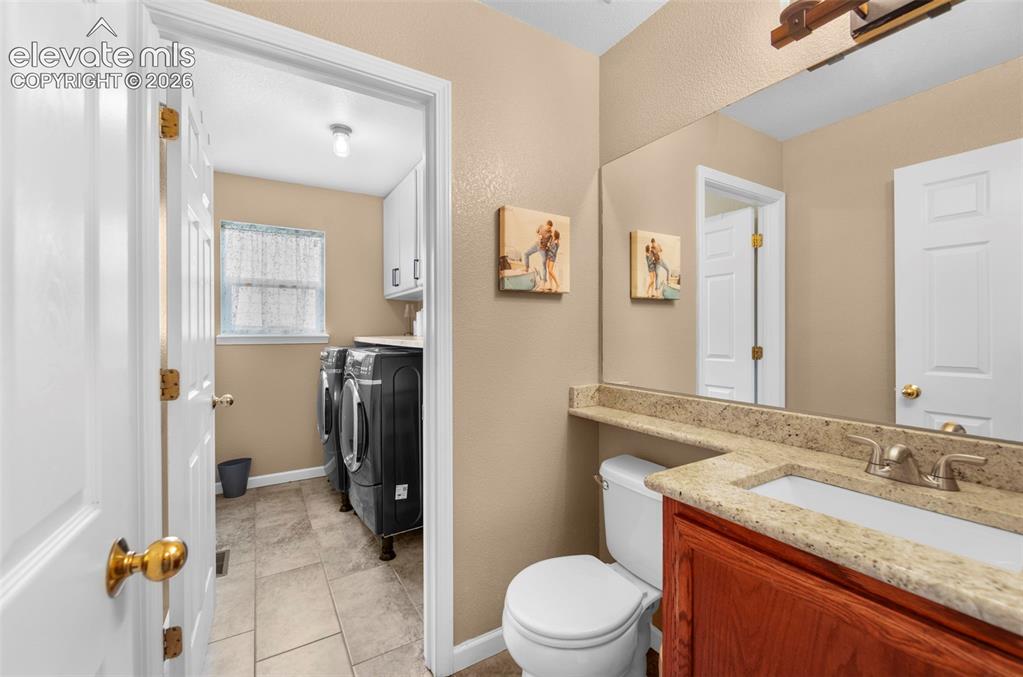 Image 15 of 41: Bathroom vanity featuring a granite-style countertop, undermount sink, and