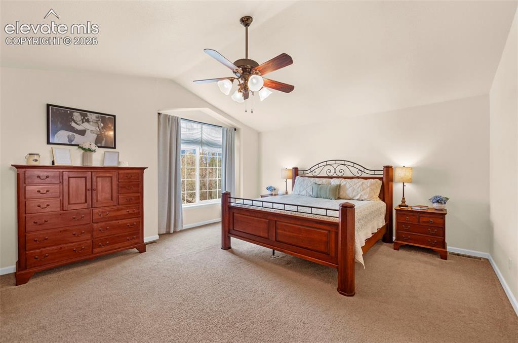 Image 18 of 41: Spacious bedroom featuring vaulted ceilings, bay window, ceiling fan, and c