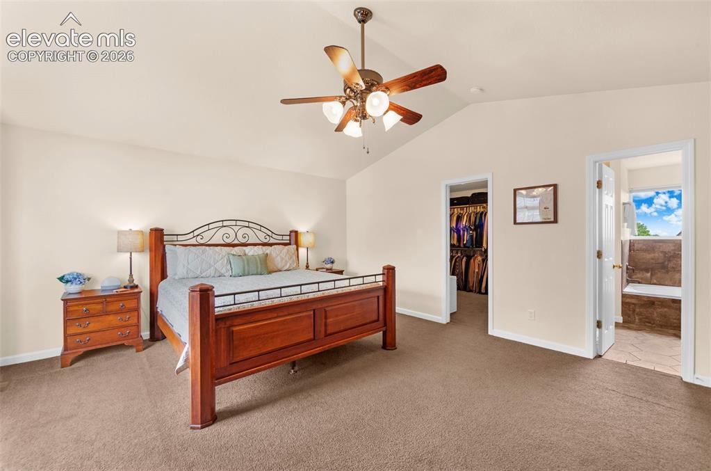 Image 19 of 41: Spacious room featuring vaulted ceilings, a ceiling fan, plush carpet floor