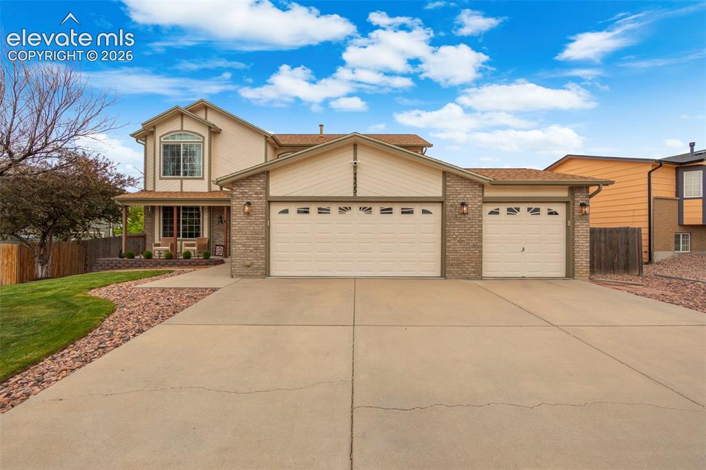Image 2 of 41: Two-story residence featuring a brick and siding exterior, an arched bay wi