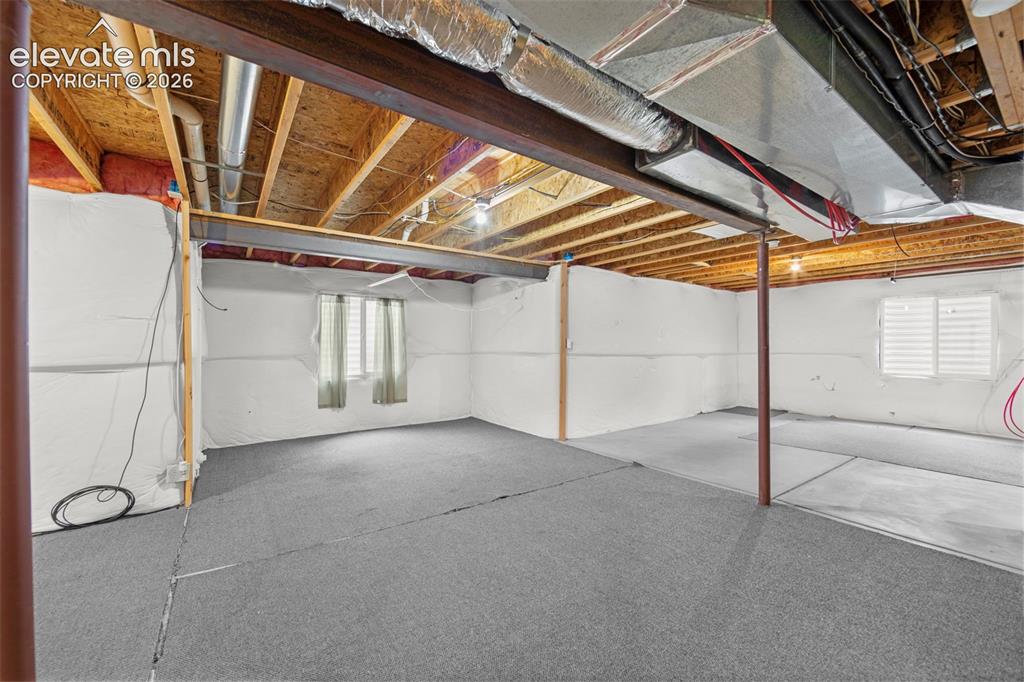 Image 26 of 41: Expansive lower level with both carpeted and concrete flooring sections