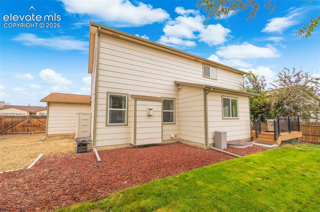 Image 29 of 41: Rear exterior featuring a multi-level wood deck with black metal railings,