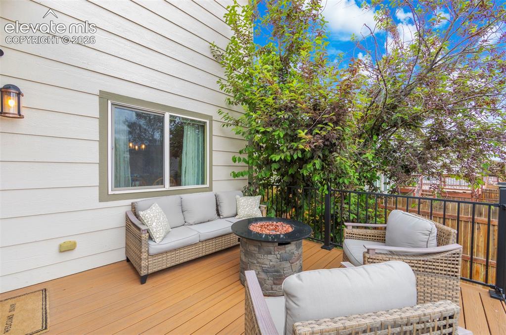 Image 30 of 41: Private exterior deck featuring composite decking, white siding, and a blac