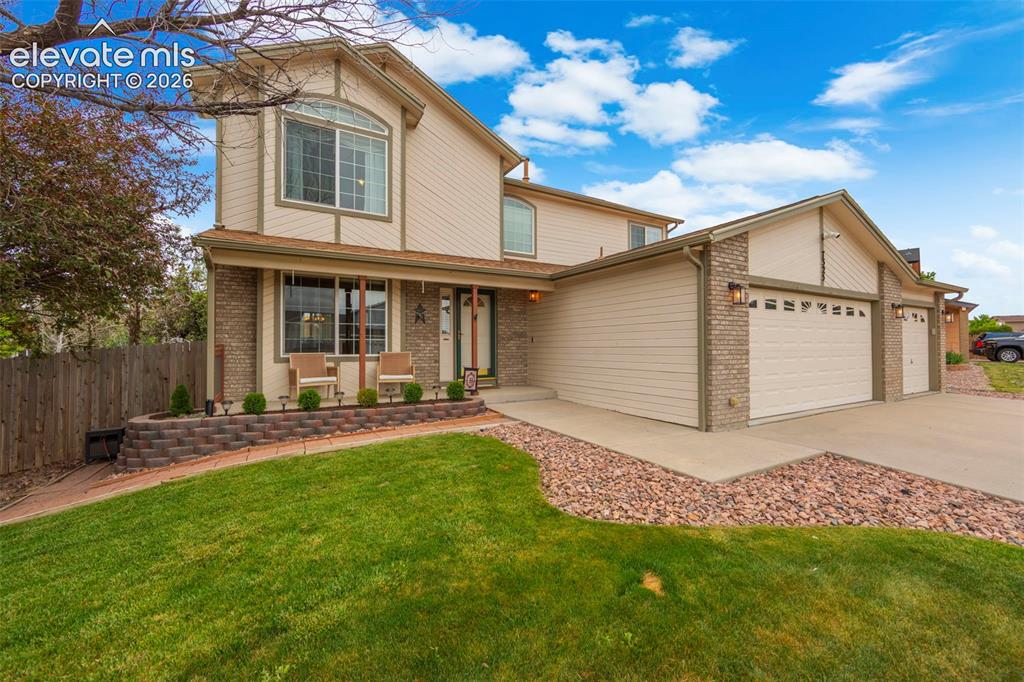Image 5 of 41: Exterior featuring a multi-car driveway, attached garage, and a brick facad