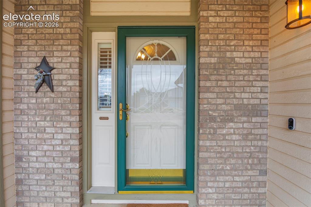 Image 6 of 41: Entryway featuring light-toned brick veneer, horizontal siding, and a promi