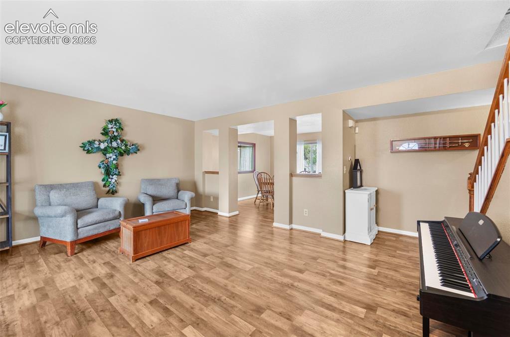 Image 7 of 41: Spacious living area featuring wood-finish flooring, neutral wall tones, an