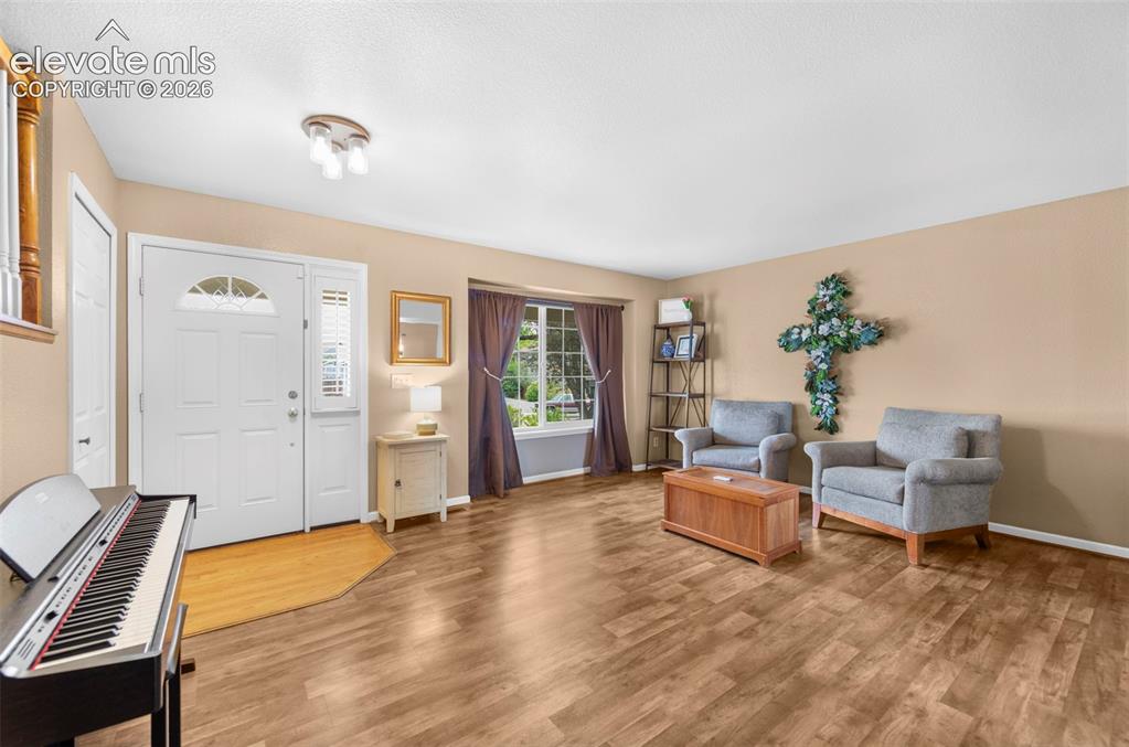 Image 8 of 41: Living area featuring wood-finish flooring, a white paneled front door with