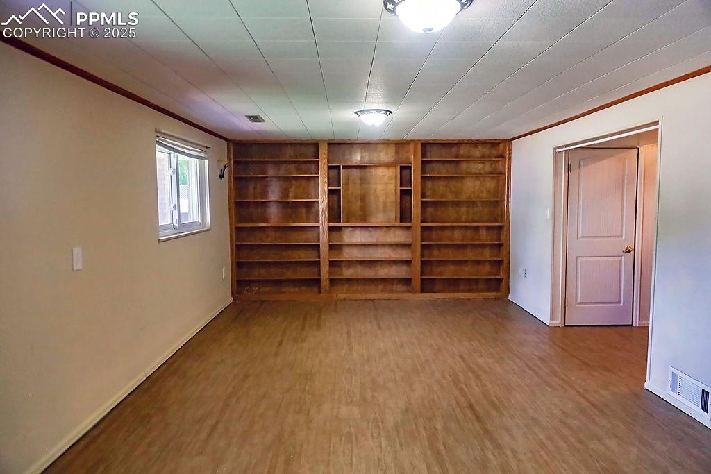 Image 30 of 50: Lower Level Family Room with Built-In Shelving