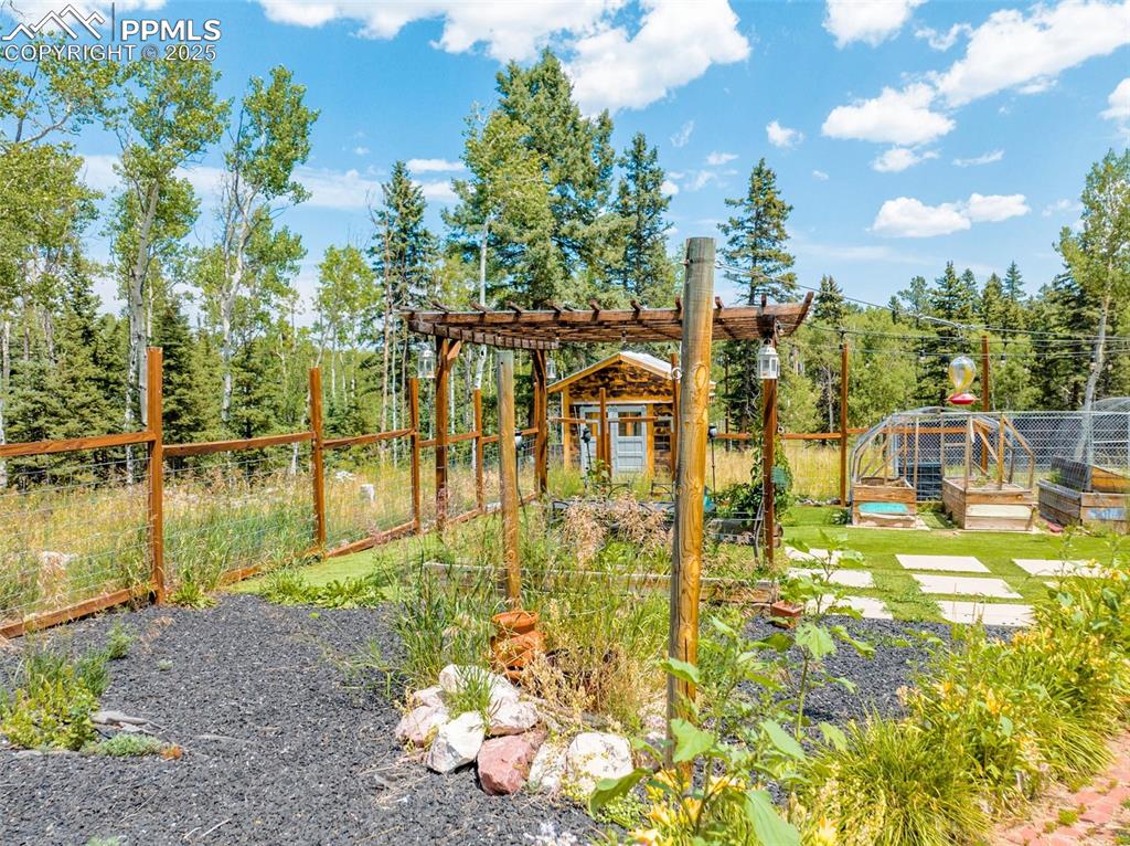 Image 44 of 50: Beautifully enclosed flower garden with a tranquil sitting area