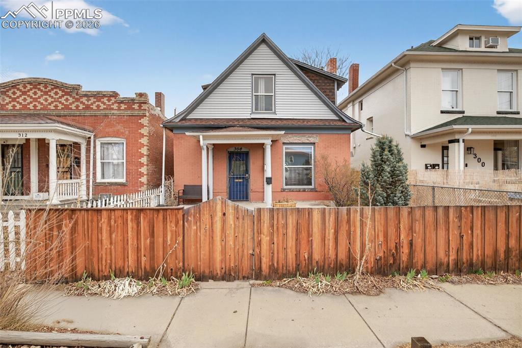 Caption: Charming historic Denver bungalow with classic brick exterior, steep gabled roofline, and inviting f