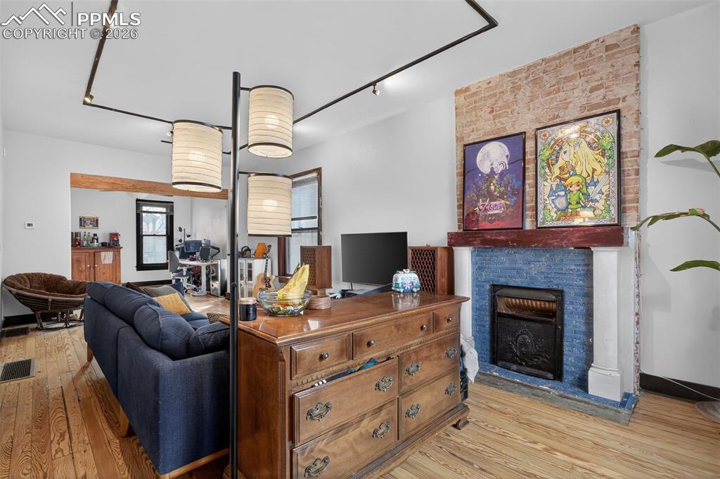 Image 2 of 38: Warm and inviting living area featuring exposed brick accents, hardwood flo
