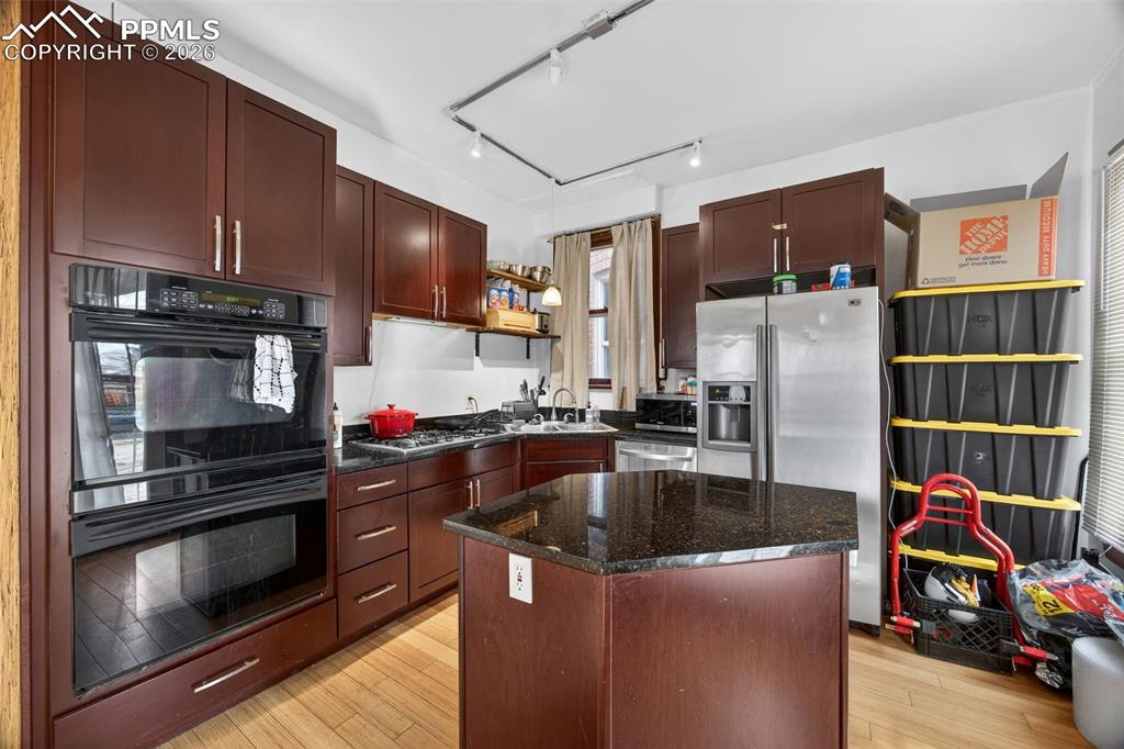 Image 3 of 38: Updated kitchen with rich wood cabinetry, granite or solid surface counters