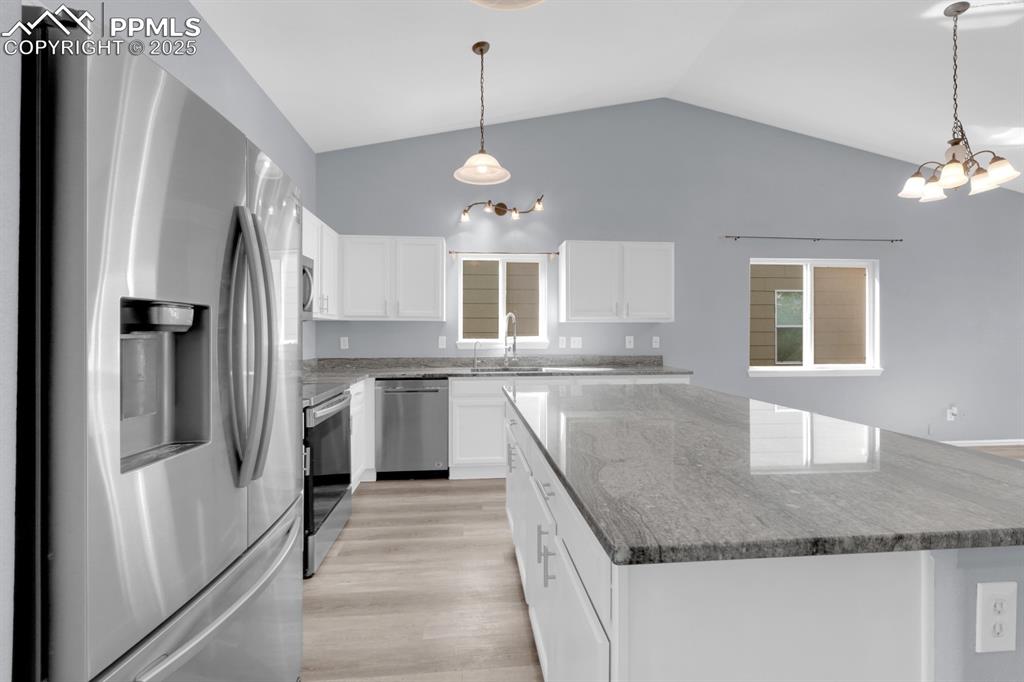 Image 9 of 36: Kitchen featuring Granite Countertops, an Island and an Eat In Dining Area