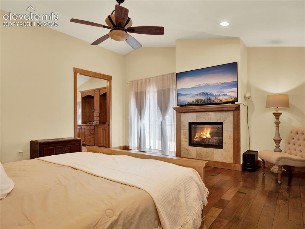 Image 19 of 43: Main level primary bedroom complete with a gas fireplace and access to an o