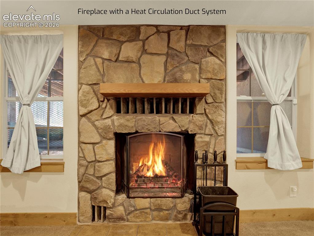 Image 35 of 43: Large wood burning fire place that is uniquely designed with heat circulati