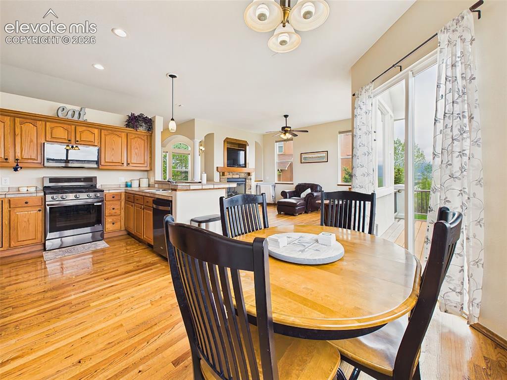 Image 11 of 50: Open kitchen and dining space with hardwood floors, easy deck access, and s
