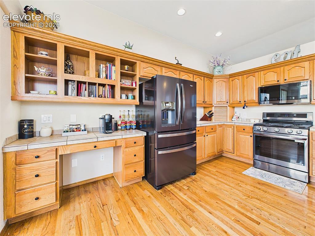 Image 12 of 50: Bright kitchen with abundant cabinetry, updated appliances, and a convenien