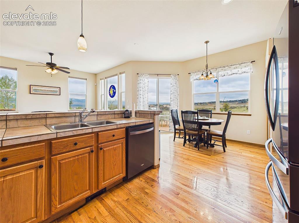 Image 14 of 50: Spacious kitchen layout with extensive counter space, hardwood flooring, an