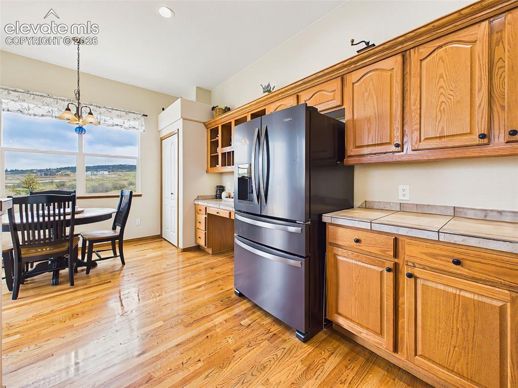 Image 15 of 50: Light-filled kitchen and breakfast nook overlooking scenic open space views