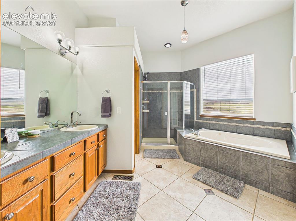 Image 19 of 50: Generously sized primary bathroom with tile flooring, expansive vanity spac